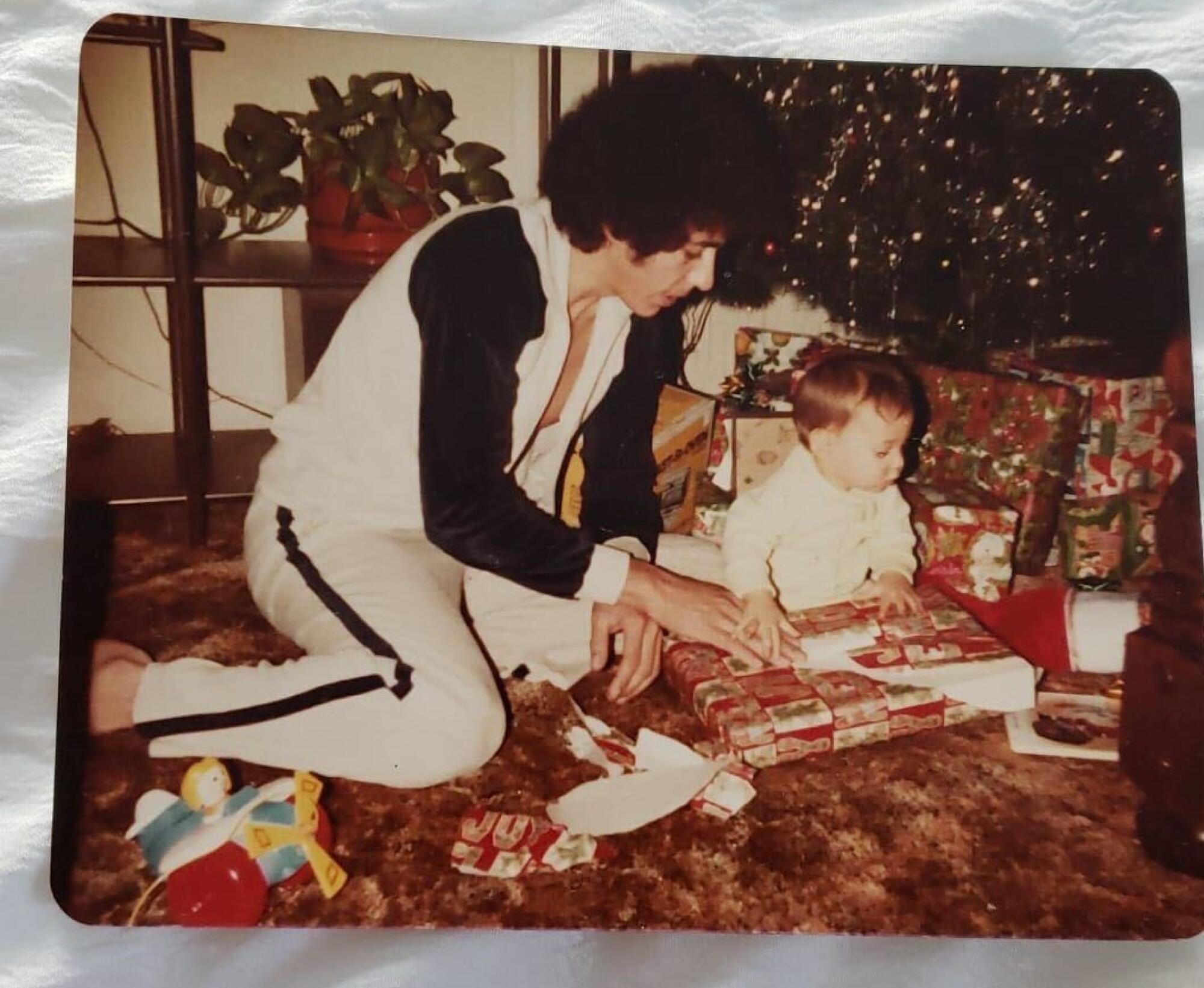 Jesse Saenz, right, opens a Christmas gift with help from his father, Ignacio.
