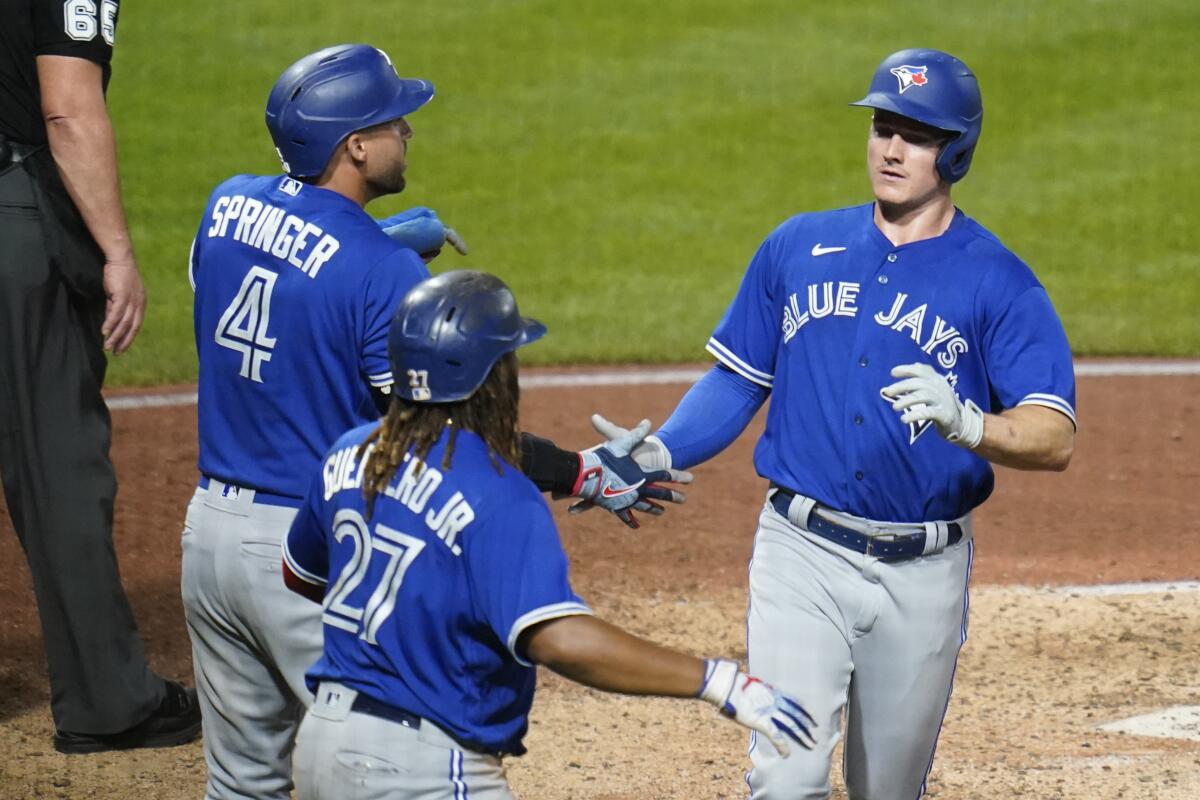 Toronto Blue Jays' Matt Chapman, right, George Springer (4), and Vladimir Guerrero Jr. (27), celebrate after scoring on a double by Bo Bichette during the seventh inning of the team's baseball game against the Pittsburgh Pirates, Saturday, Sept. 3, 2022, in Pittsburgh. (AP Photo/Keith Srakocic)