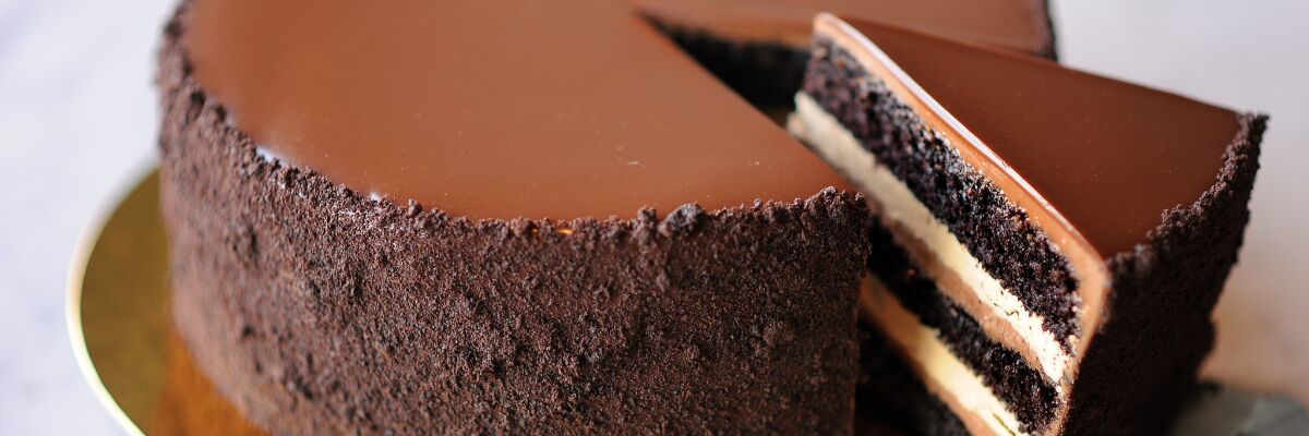 A Chocolate Espresso Cake with a slice partly removed, showing the layers of cake.