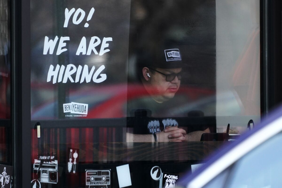 FILE - A hiring sign is displayed at a restaurant in Schaumburg, Ill., Friday, April 1, 2022. More Americans applied for jobless benefits last week, reported Thursday, Aug. 4, 2022, as the number of unemployed continues to rise modestly, though the labor market remains one of the strongest parts of the U.S. economy. (AP Photo/Nam Y. Huh, File)
