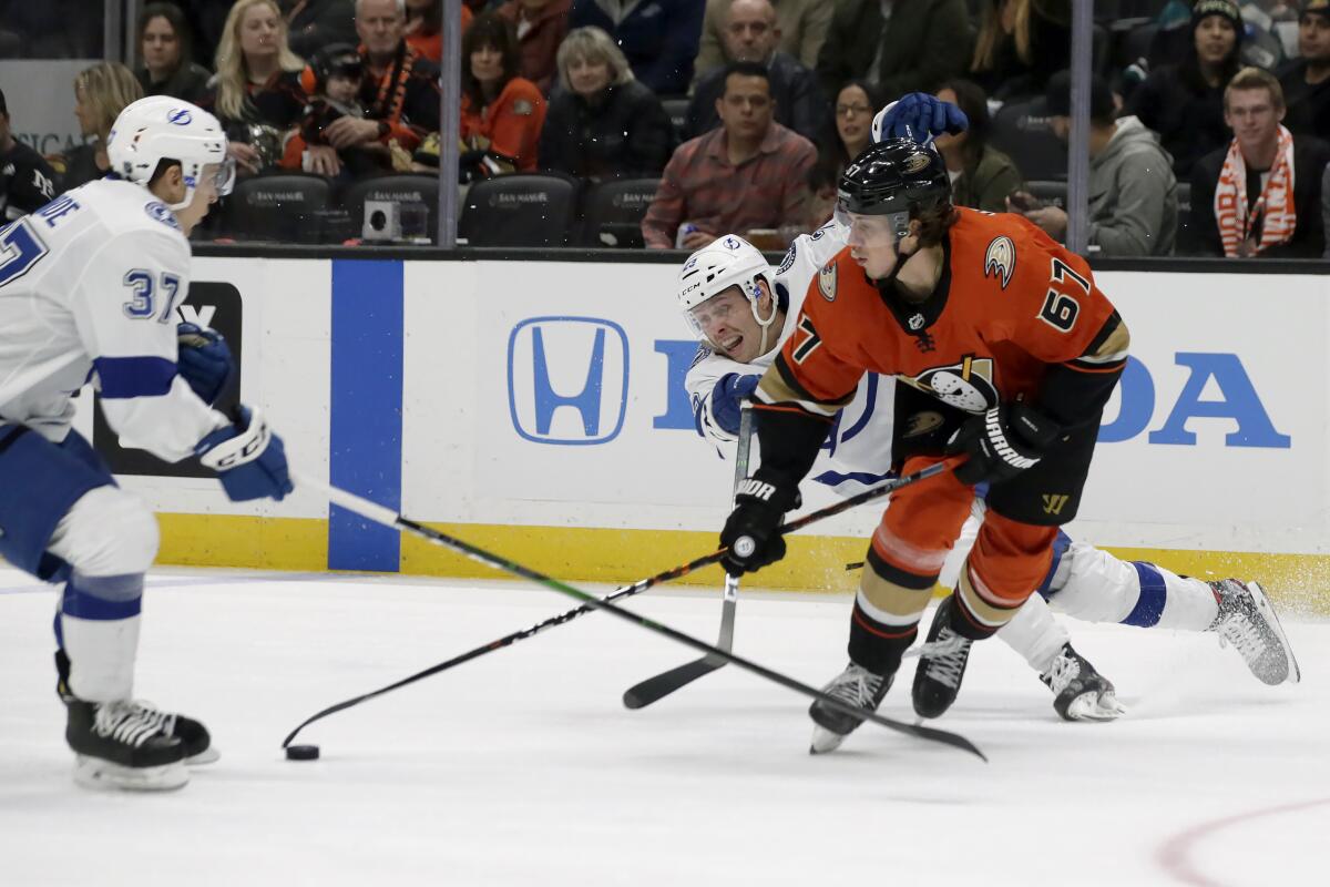 The Ducks' Rickard Rakell (67) vies for the puck against the Lightning's Yanni Gourde, left, and Carter Verhaeghe on Jan. 31, 2020.