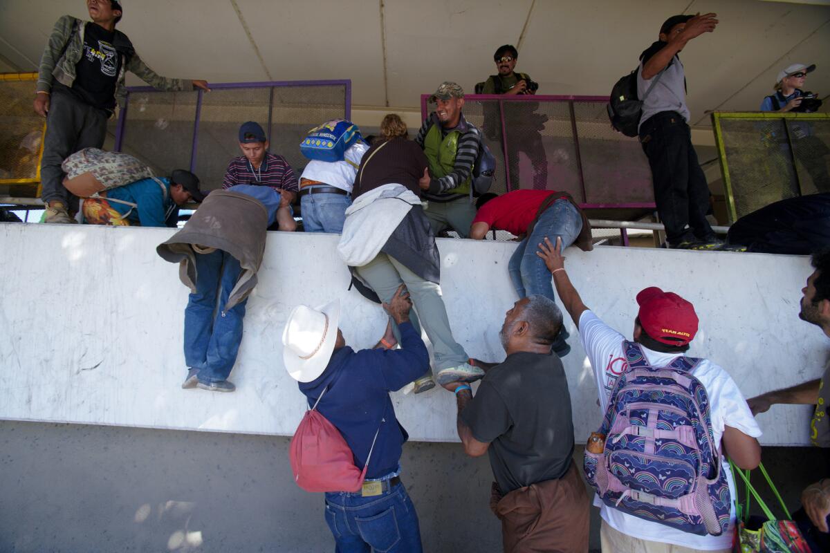 Migrants with the Central American caravan breach police line set up by the Mexico Federal Police, then try to access the San Ysidro Port of Entry.