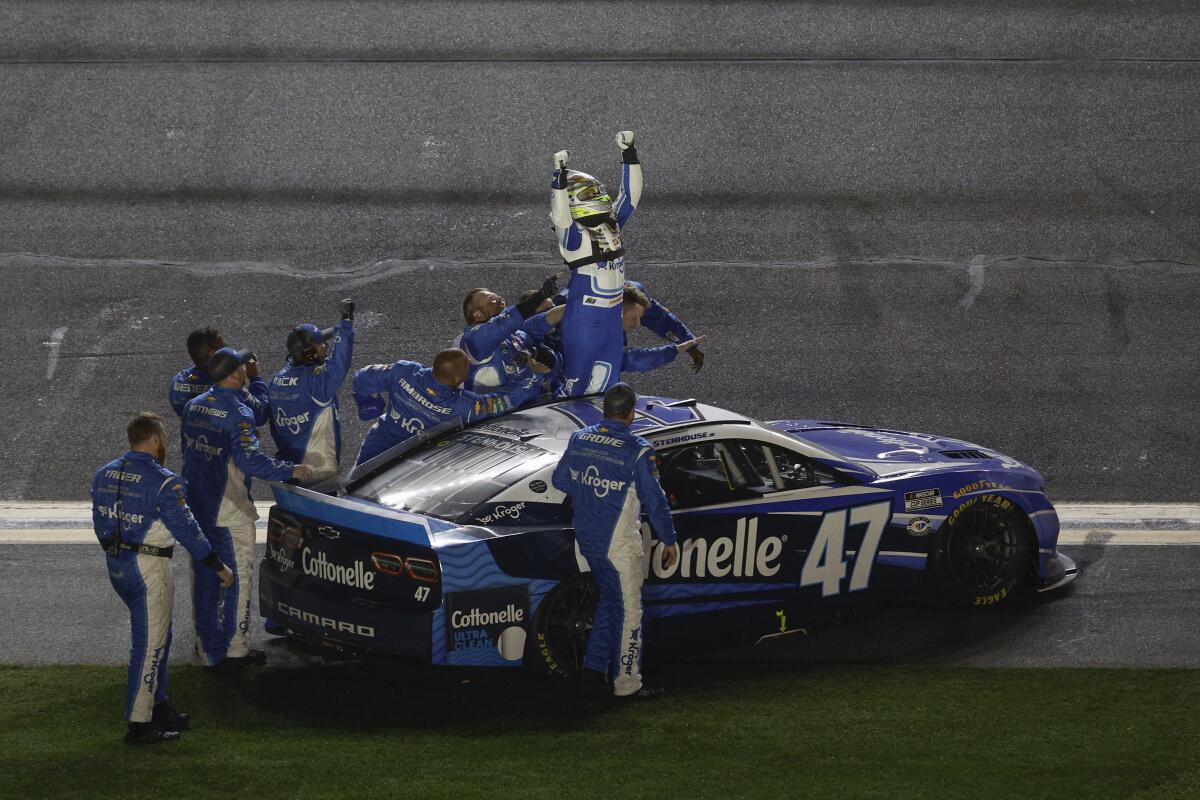 Ricky Stenhouse Jr. celebrates with his crew on the track after winning the Daytona 500.