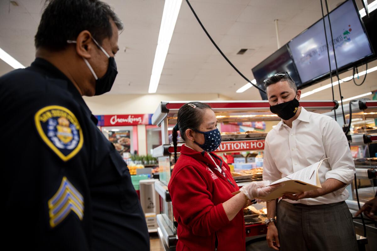 Councilmember Chris Cate, right, speaks with assistant manager Miriam Advincula at Seafood City Supermarket in Mira Mesa.