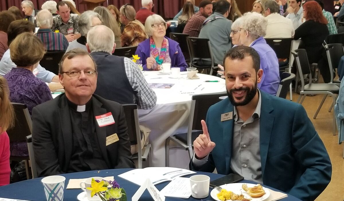 Father Steve Callahan and Issam Lagrichi are among the Interfaith Coalition Prayer Breakfast attendees.
