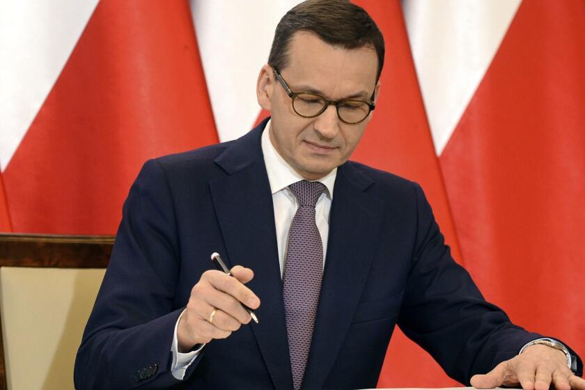 Polish Prime Minister Mateusz Morawiecki signs the Joint Declaration of Prime Ministers of the State of Israel and the Republic of Poland, in his chancellery in Warsaw, Poland, Wednesday, June 27, 2018. Poland suddenly backtracked Wednesday on a disputed Holocaust speech law, scrapping the threat of prison for attributing Nazi crimes to the Polish nation. The original law, which was passed five months earlier, had supposedly been aimed at defending the country's "good name" â but mostly had the opposite effect. (AP Photo/Alik Keplicz)