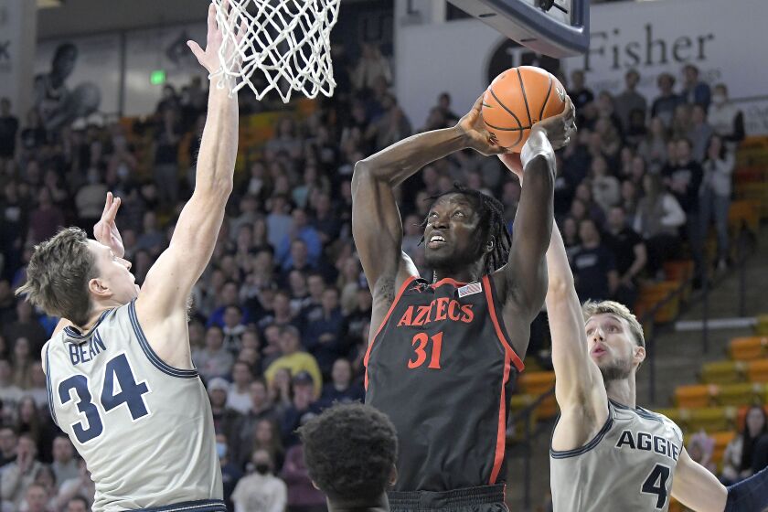 SDSU senior Nathan Mensah goes up to dunk the ball against Utah State's Justin Bean (34) for two of his four points.