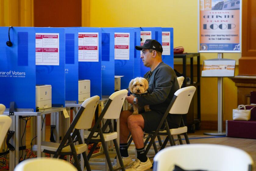 Matt Omar and his dog, Mr Diggs cast his vote at the voting center located at the San Diego LGBT Community Center.