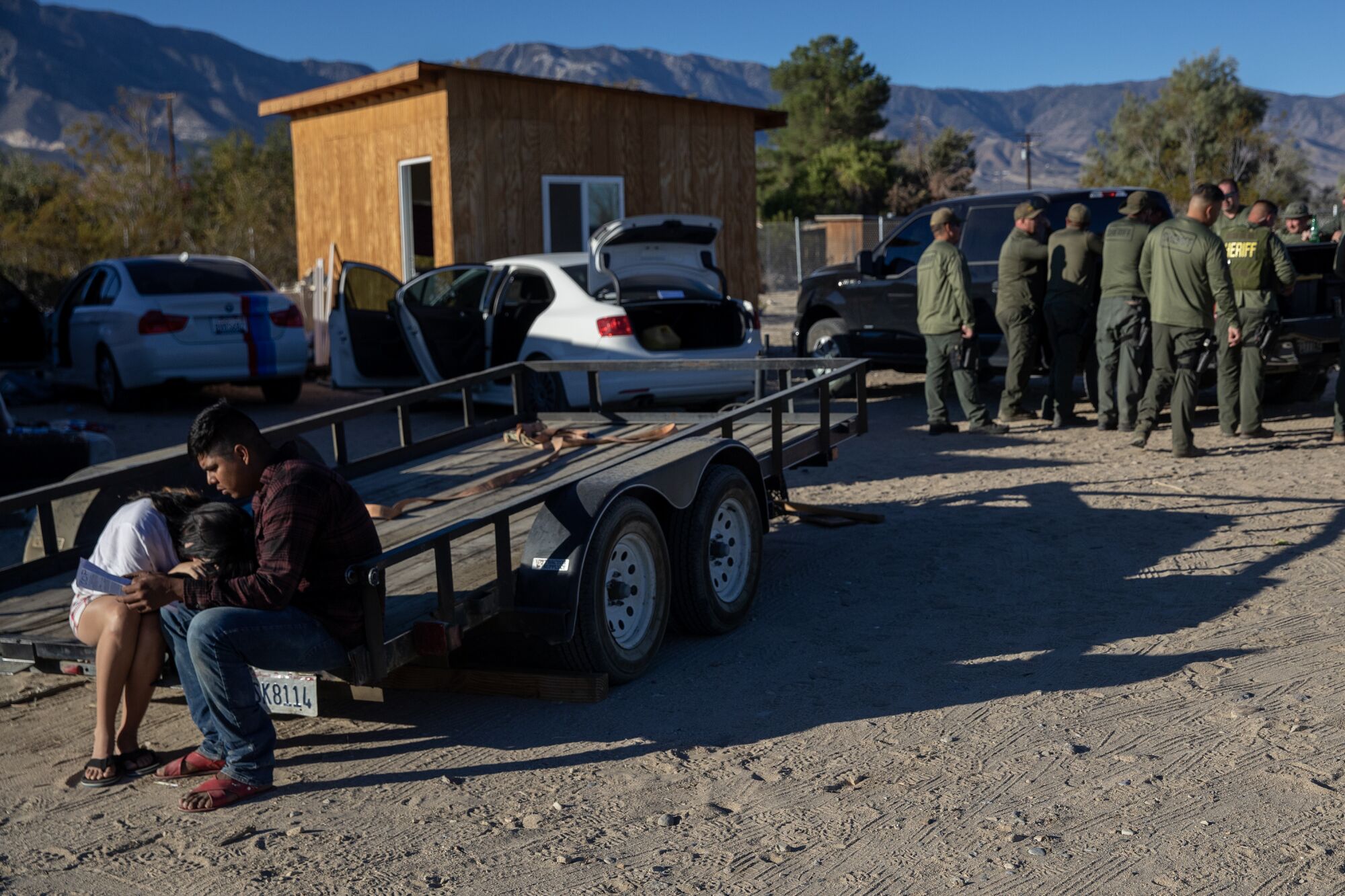Two cannabis workers comfort each other during a raid in San Bernardino County.