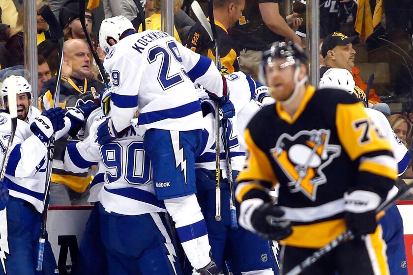 Lightning players celebrate their overtime win as Penguins winger Patric Hornqvist skates off the ice Sunday night in Pittsburgh.