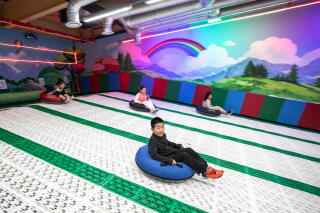 Children slide on inner tubes indoors