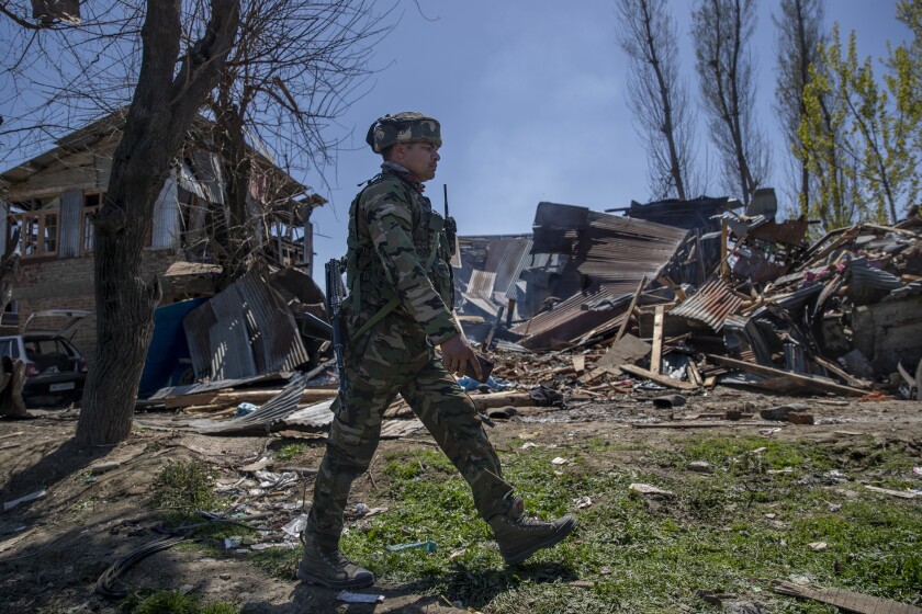 An Indian paramilitary soldier walks past a house destroyed during a gunbattle in Pulwama, south of Srinagar, Indian controlled Kashmir, Friday, April 2, 2021. Anti-India protests and clashes have erupted between government forces and locals who thronged a village in disputed Kashmir following a gunbattle that killed three suspected militants. Police say the gunfight on Friday erupted shortly after scores of counterinsurgency police and soldiers launched an operation based on tip about presence of militants in a village in southern Pulwama district. (AP Photo/ Dar Yasin)