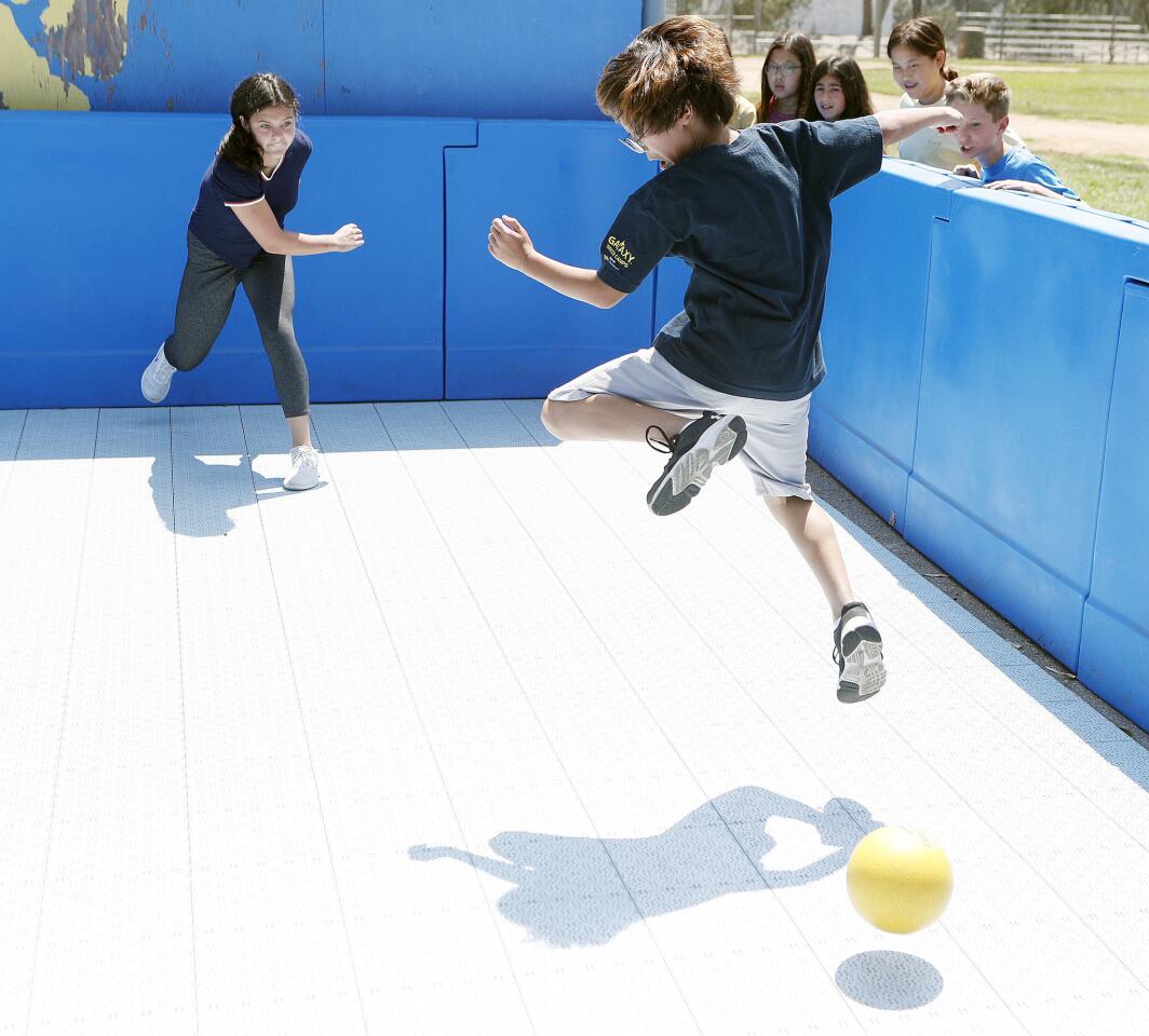 Cody Mora, 12, hits the ball making opponent Keoney Lee, 11, jump to avoid being hit in a newly installed gaga pit for students to play gaga ball at La CaÃ±ada Elementary School on Tuesday, August 21, 2018. The game is a lot like dodge ball, but the ball is hit with a hand and is live until an opponent hits the ball with their hand. If the ball hits you before you can hit it, your out.