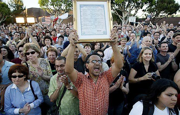 Raul Castro cheers as he holds up his San Francisco marriage certificate from 2004, stating his marriage to Robert Bergstein, (left of Castro), joining thousands of people in West Hollywood to celebrate the court's decision.