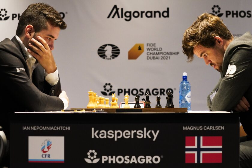 Ian Nepomniachtchi of Russia, left, and Magnus Carlsen of Norway, right, compete during the FIDE World Championship at Dubai Expo 2020 in Dubai, United Arab Emirates, Friday, Dec. 10, 2021. (AP Photo/Jon Gambrell)