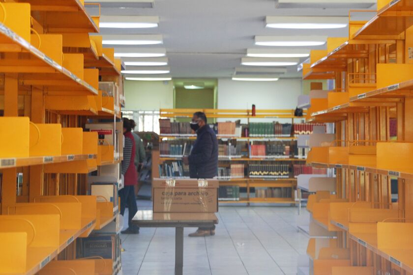 Estantes lucen vacíos mientras los empleados acomodan libros en cajas 