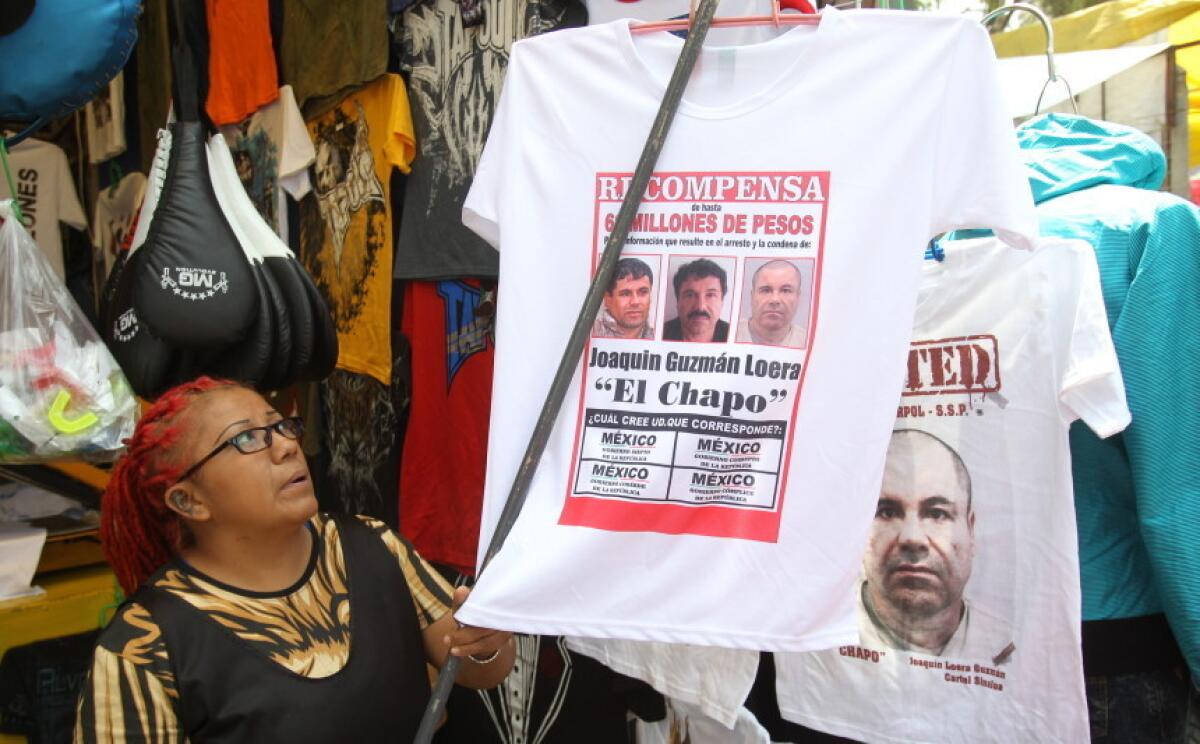 Una comerciante organiza camisetas con imágenes y frases alusivas al fugado narcotraficante Joaquín "El Chapo" Guzmán.