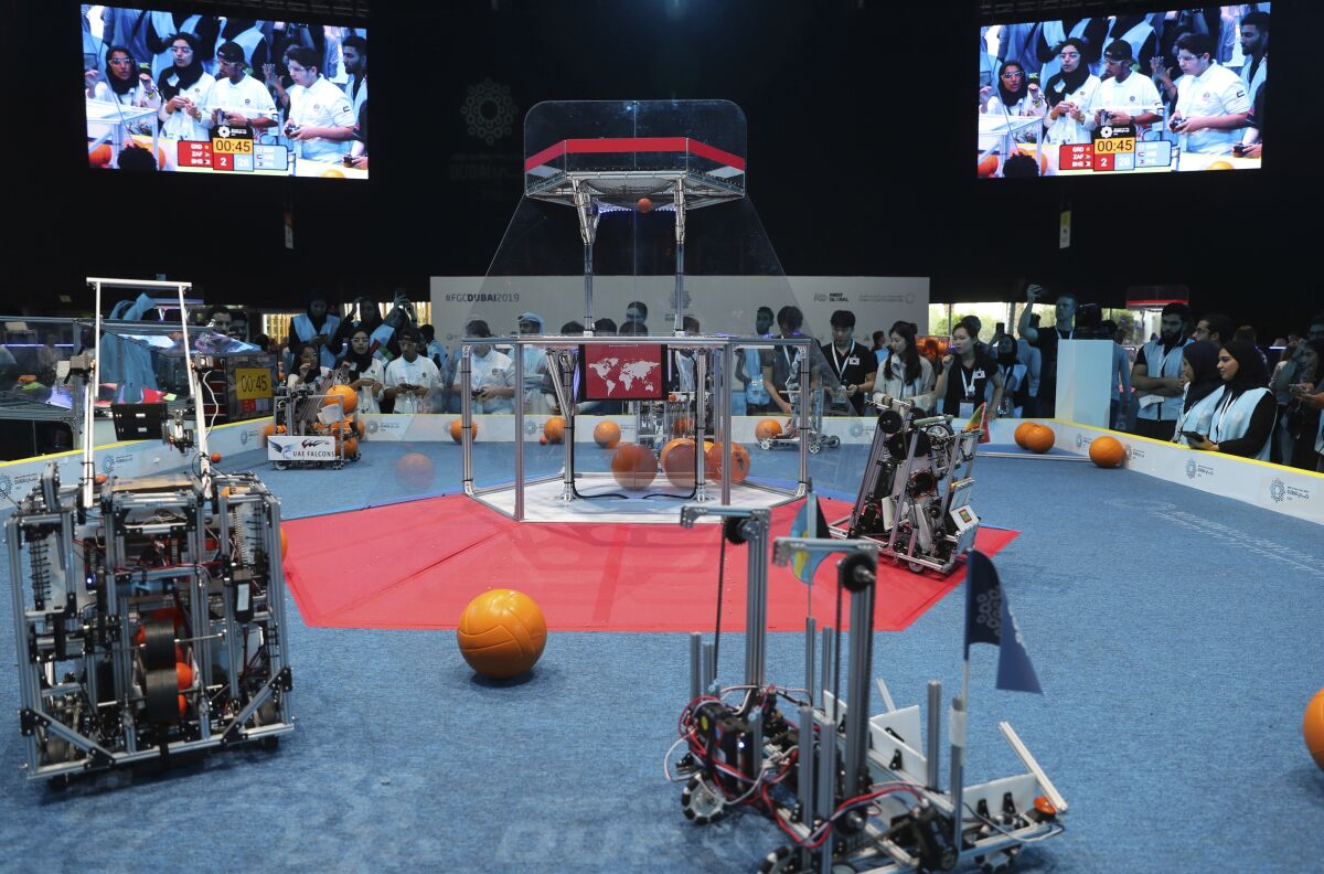In this Friday, Oct. 25, 2019 photo, a team from Korea, on the right, competes with UAE Falcons during the First Global Challenge, a robotics and artificial intelligence competition in Dubai, United Arab Emirates. Seeking to bolster its image as a forward-looking metropolis, Dubai hosted the largest-ever international robotics contest this week, challenging young people from 190 countries to find solutions to global ocean pollution. (AP Photo/Kamran Jebreili)