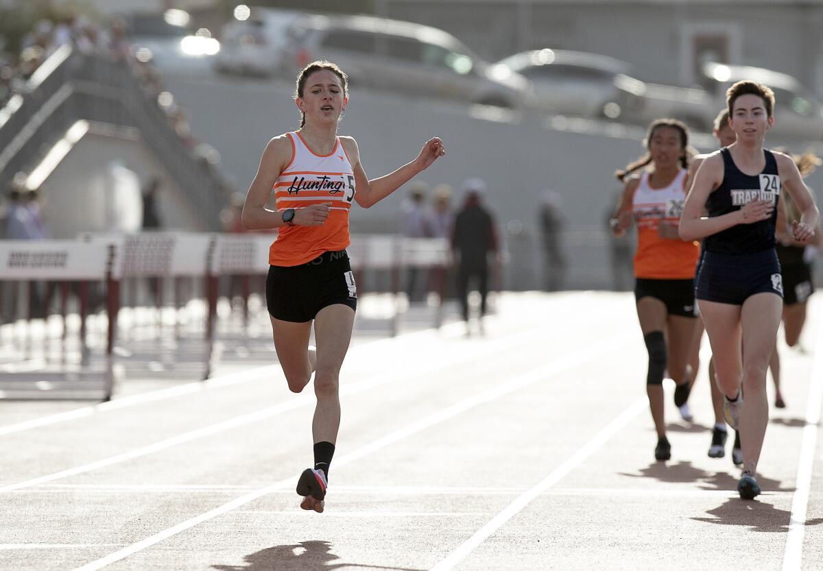 Huntington Beach's Makenzie McRae, left, finishes first in the Eric Hulst Invitational girls' 3,200-meter run.