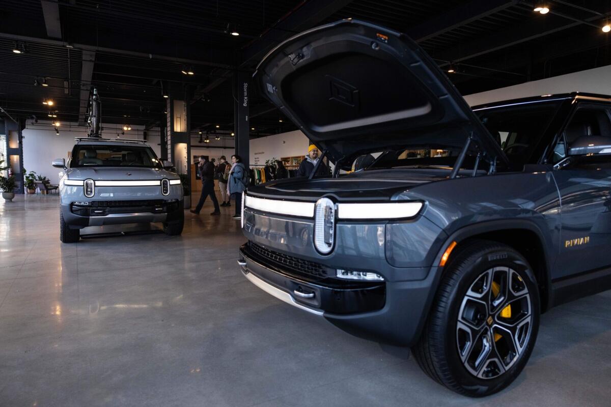 A Rivian R1T electric vehicle (EV) pickup truck, left, and R1S electric sports utility vehicle (SUV) 