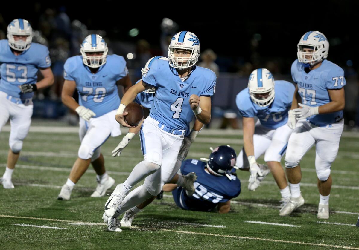 Corona del Mar quarterback Ethan Garbers carries the ball in the Battle of the Bay game against Newport Harbor on Friday at Davidson Field.