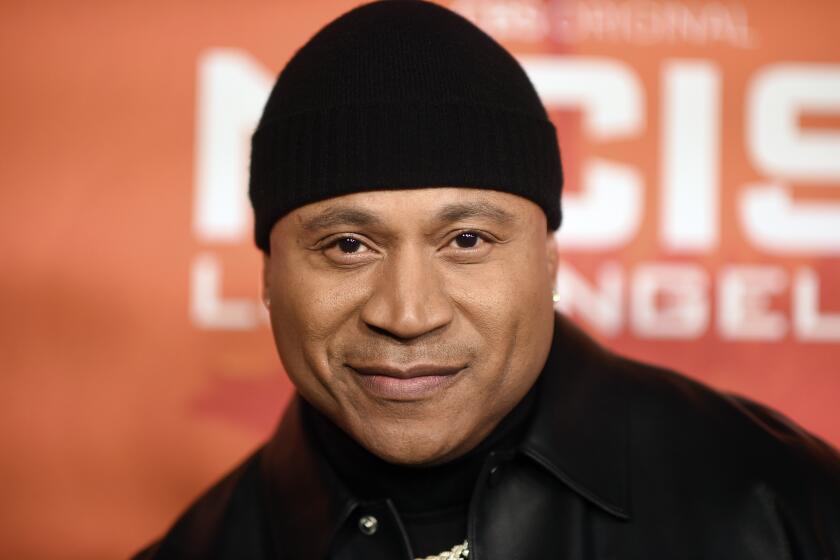 LL Cool J looks into the camera while wearing a black beanie and leather jacket.