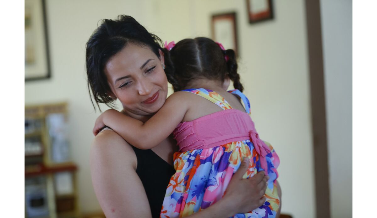 Happy to be back at home in the north county, Maria Solis tends to the needs of one of her children.
