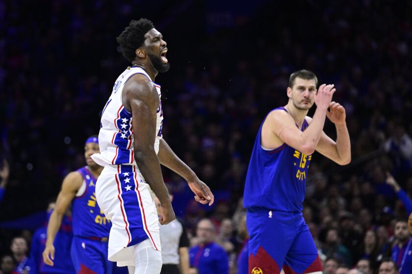 Philadelphia 76ers' Joel Embiid, left, reacts after a shooting foul was called against Denver Nuggets' Nikola Jokic, right, during the second half of an NBA basketball game, Saturday, Jan. 28, 2023, in Philadelphia. (AP Photo/Derik Hamilton)