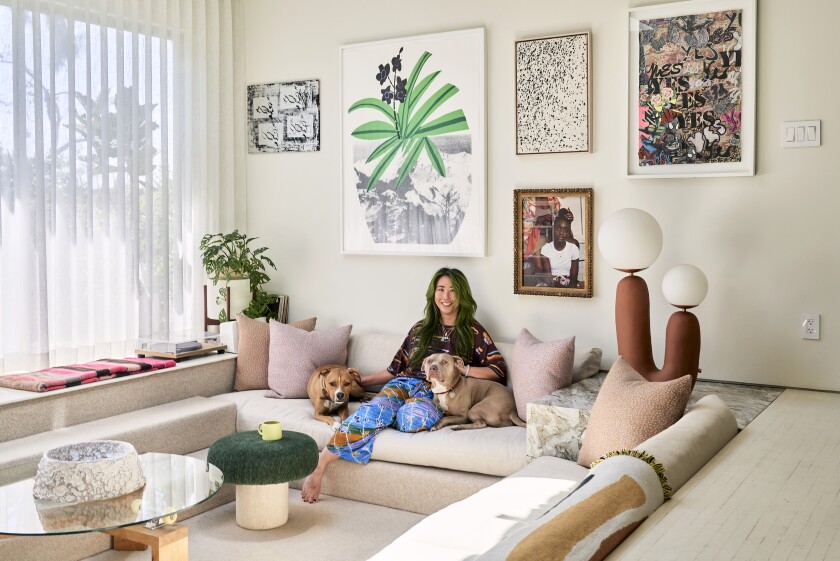 A woman sits with her dogs in the conversation pit of her Los Angeles home.
