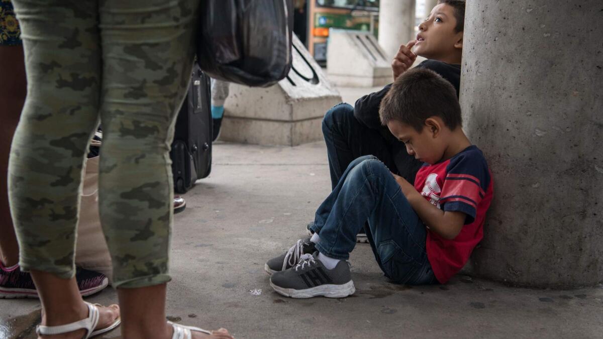 Central American migrant families wait to board a bus in McAllen, Texas, this month after being released from federal detention.