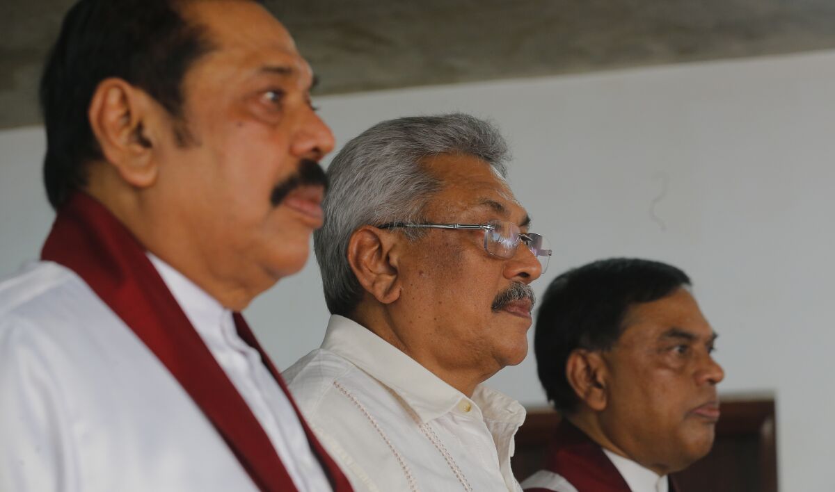 FILE - Sri Lanka's former president Mahinda Rajapaksa, left, along with his brothers former defense secretary Gotabaya Rajapaksa, center, and former economics development minister Basil Rajapaksa, attend a meeting at their party office with local politicians in Colombo, Sri Lanka, July 4, 2018. With one brother president, another prime minister and three more family members cabinet ministers, it appeared that the Rajapaksa clan had consolidated its grip on power in Sri Lanka after decades in and out of government. With a national debt crisis spiraling out of control, it looks like the dynasty is nearing its end with Prime Minister Mahinda stepping down on Monday, May 9, 2022, and the three Rajapaksas resigning their cabinet posts in April, but the family is not going down without a fight. (AP Photo/Eranga Jayawardena, File)