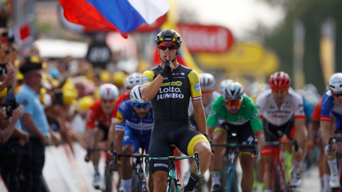Dylan Groenewegen gestures for silence as he crosses the finish line to win the seventh stage of the Tour de France on July 13.
