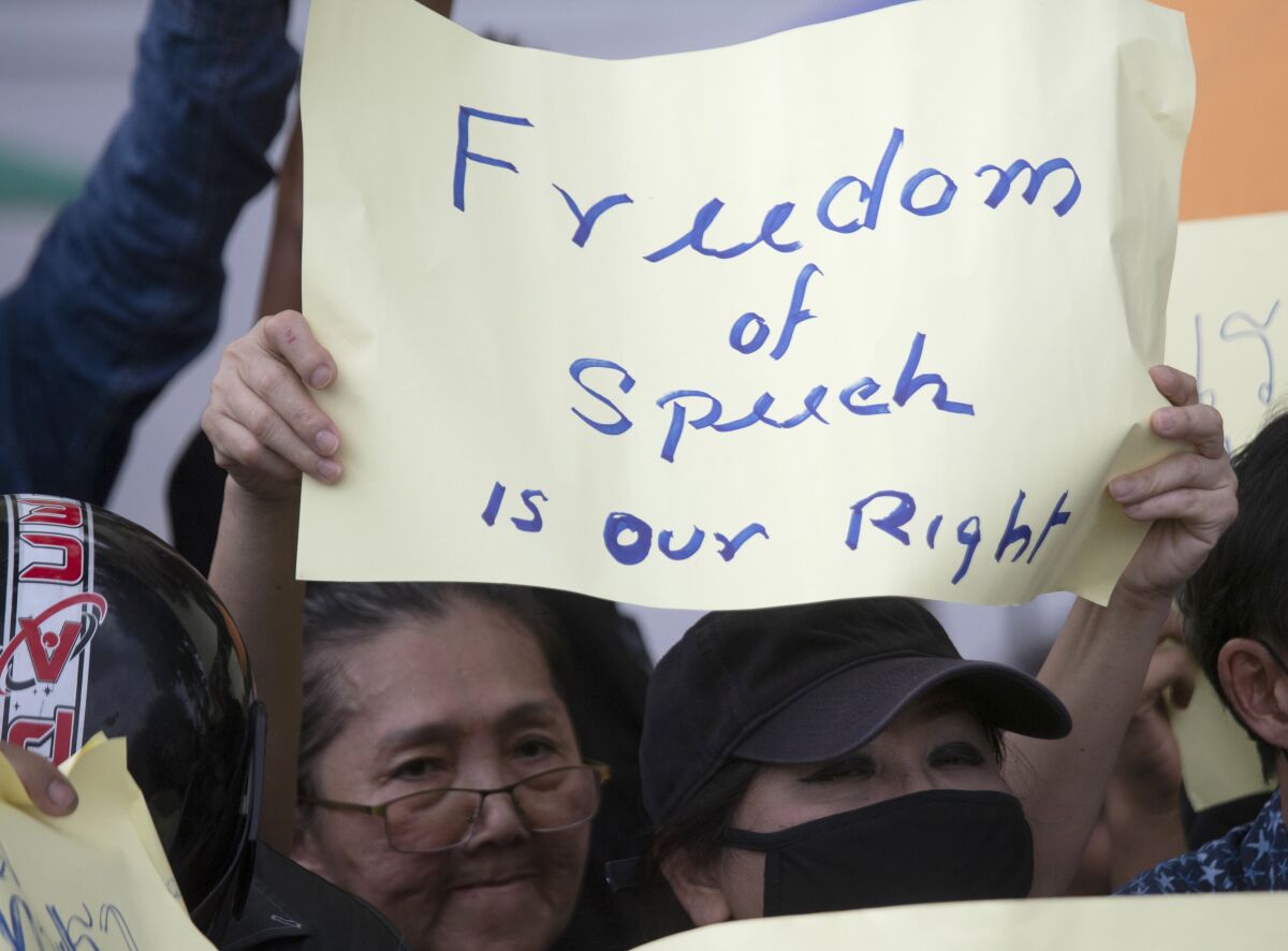 A pro-democracy protester holds up a poster during a rally in Bangkok, Thailand, Sunday, Aug, 16, 2020. Protesters have stepped up pressure on the government if it failed to meet their demands, which include holding of new elections, amending the constitution, and an end to intimidation of critics. (AP Photo/Sakchai Lalit)