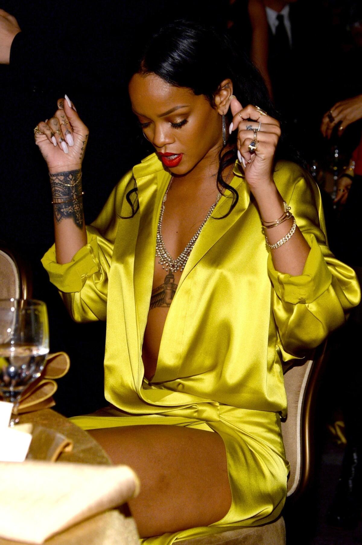 Rihanna seems surprised that her wrap dress is coming unwrapped during the Pre-Grammy Gala at the Beverly Hilton on Saturday in Beverly Hills.