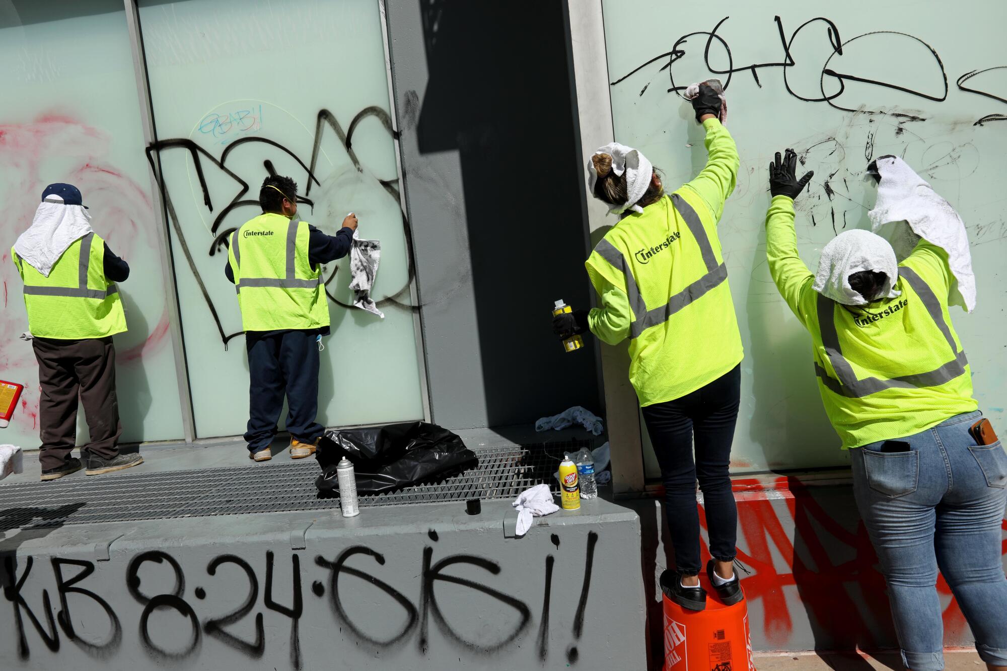 Interstate Restoration workers wash off graffiti on the Renaissance Tower apartment building on Olympic Boulevard.