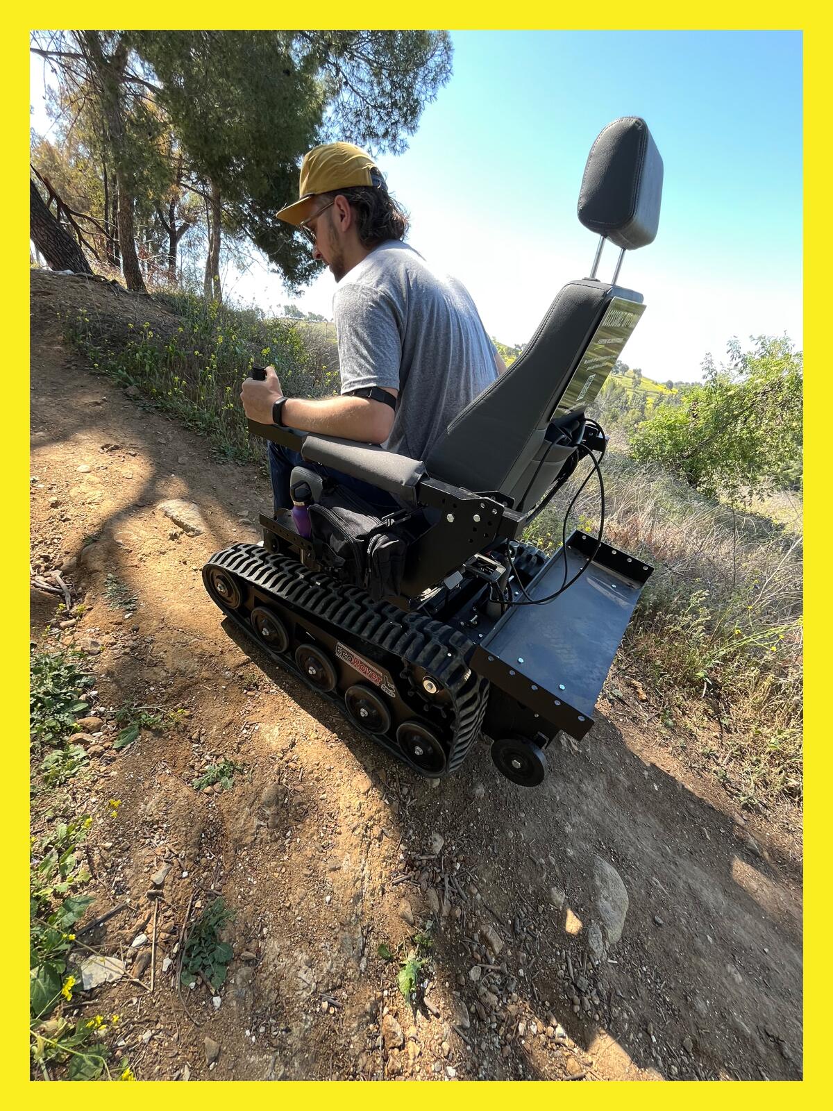 photo of a man in an electric wheelchair climbing a hill on a hiking trail