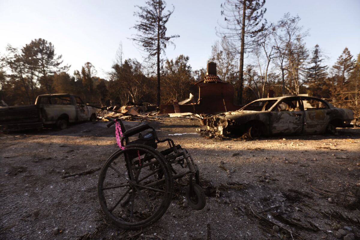 The charred remains of a wheelchair rest near two burned-out cars in Santa Rosa's Mark West Springs neighborhood.
