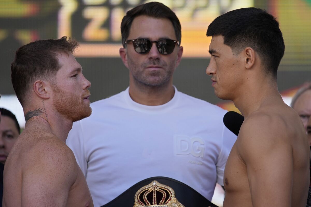 Canelo Álvarez, left, and Dmitry Bivol, right, stare each other down during a weigh-in May 6, 2022.