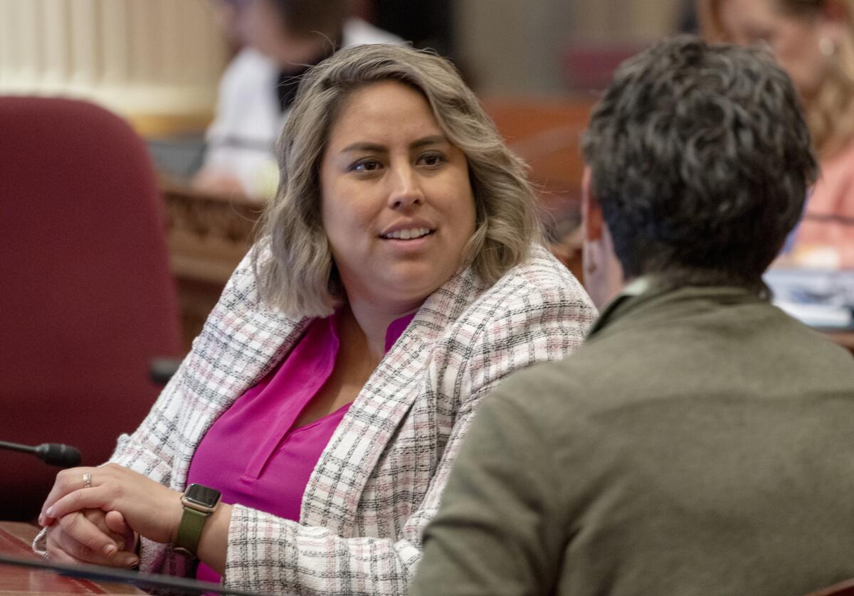State Sen. Caroline Menjivar talks with fellow lawmaker.