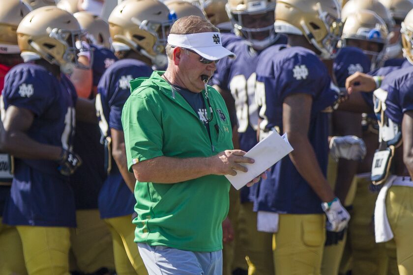Notre Dame head coach Brian Kelly looks at notes during NCAA college football practice, Thursday, Aug. 8, 2019, at the Culver Academies in Culver, Ind. (Robert Franklin/South Bend Tribune via AP)