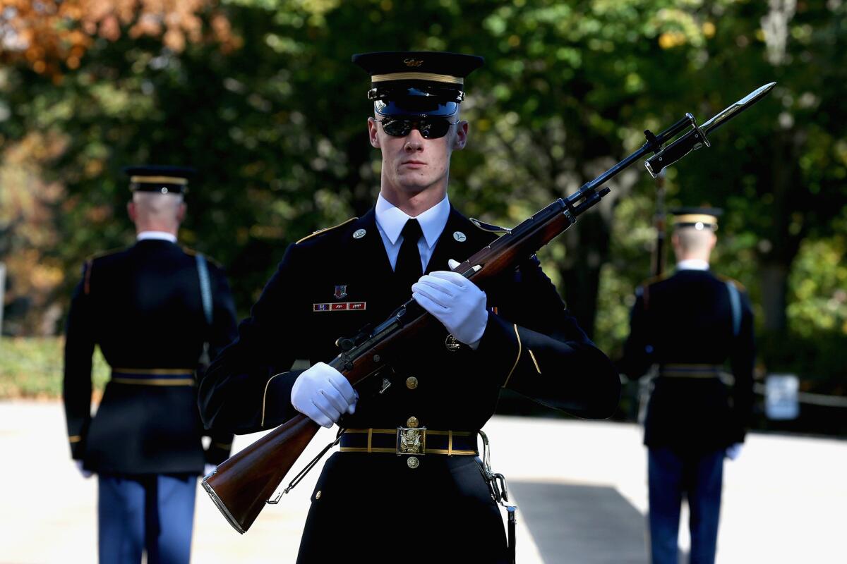 Veterans Day 2013: Members of the military color guard stand at attention before a commemorative wreath-laying ceremony at Arlington National Cemetery.