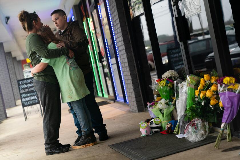 ACWORTH, GA - MARCH 17: People hug outside Youngs Asian Massage where four people were shot and killed on March 17, 2021 in Acworth, Georgia. Suspect Robert Aaron Long, 21, was arrested after a series of shootings Tuesday night at three Atlanta-area spas left eight people dead, including six Asian women. (Photo by Elijah Nouvelage/Getty Images)