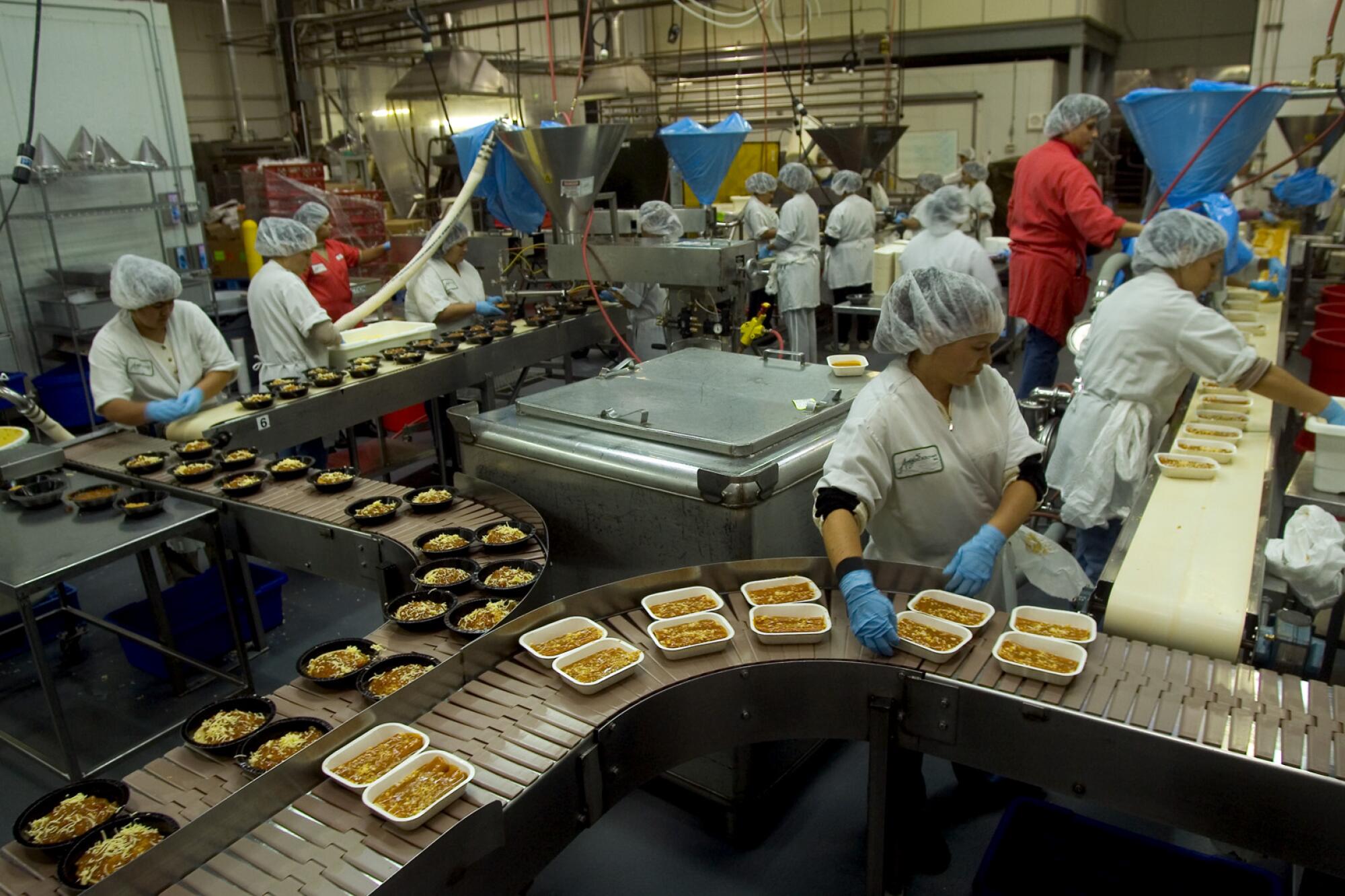 Assembly line with food trays and workers 