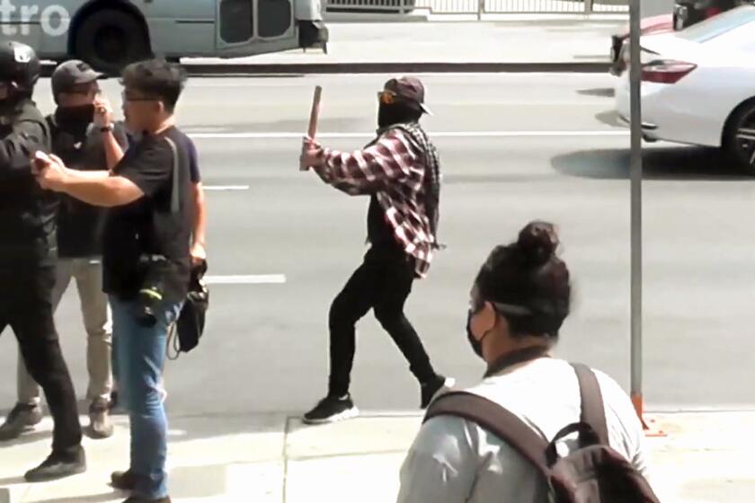 A man in a flannel shirt prepares to hit independent filmmaker Rocky Romano, far left in helmet, over the head with a bat. (Tina-Desiree Berg)