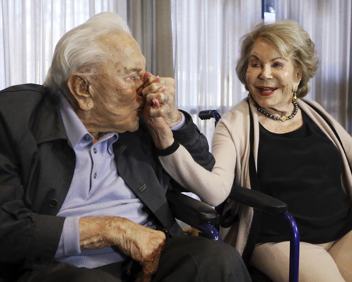 Kirk Douglas kisses his wife Anne's hand in Los Angeles