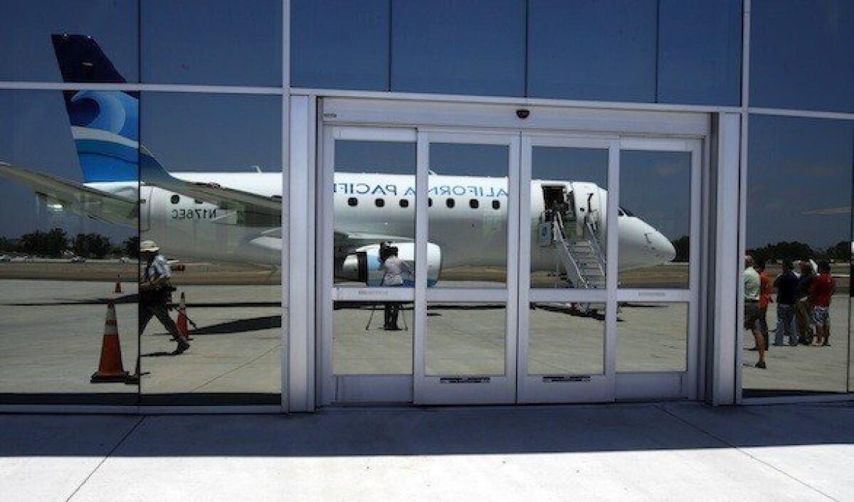 A California Pacific Airlines jet, reflected in the windows of McLellan-Palomar Airport near Carlsbad.