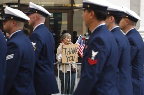 Thanksgiving: A supporter sends her regards and expresses her gratitude as troops pass by in NYC's annual Veterans Day parade.