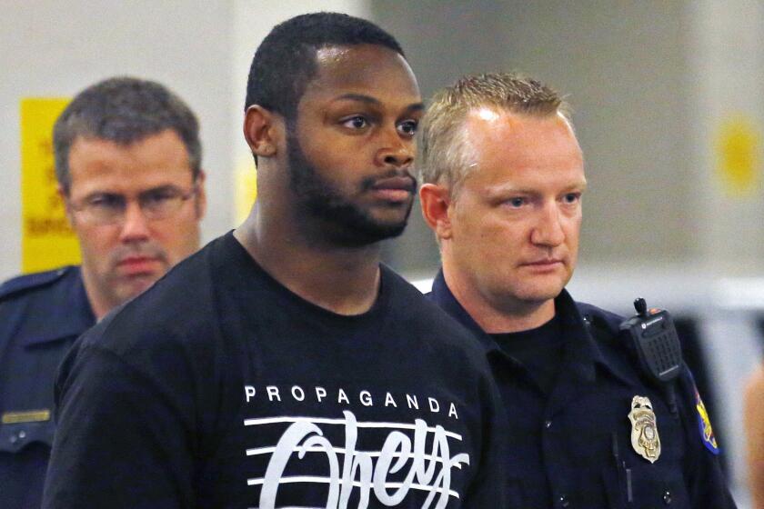 Phoenix police officers escort Arizona Cardinals running back Jonathan Dwyer to jail after his arrest on aggravated assault charges on Sept. 17.