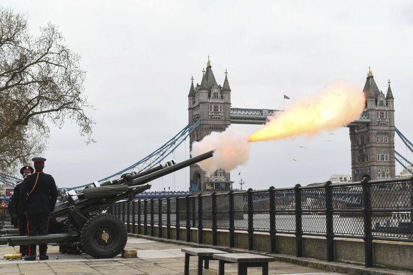 Members of the Honourable Artillery Company fire a 41-round gun salute from the wharf at the Tower of London, to mark the death of Prince Philip, in London, Saturday, April 10, 2021. Britain's Prince Philip, the irascible and tough-minded husband of Queen Elizabeth II who spent more than seven decades supporting his wife in a role that mostly defined his life, died on Friday. (Dominic Lipinski/PA via AP)