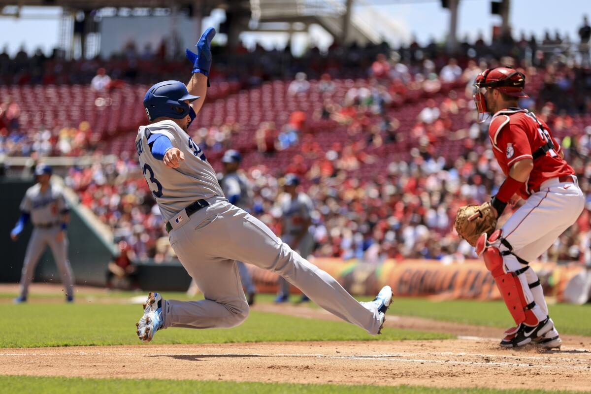 Dodger Max Muncy slides into home plate as he scores a run on a sacrifice fly by Cody Bellinger.